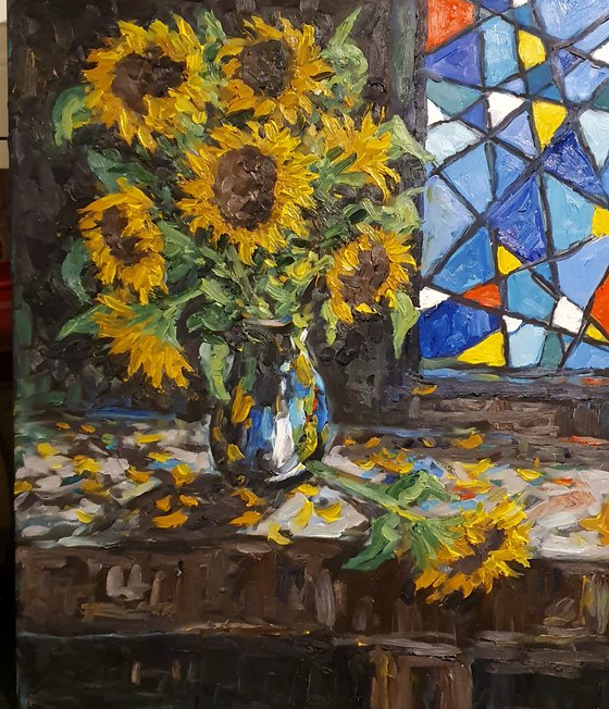 Sunflowers beside stained glass window