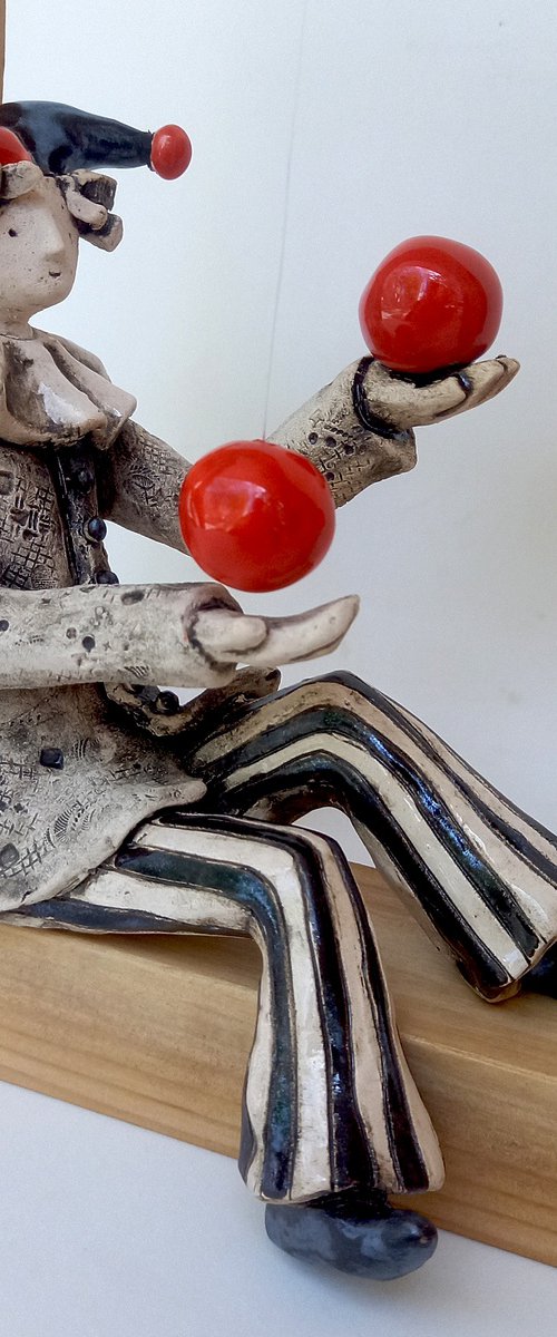 A clown playing with balls by Izabel Nemechek