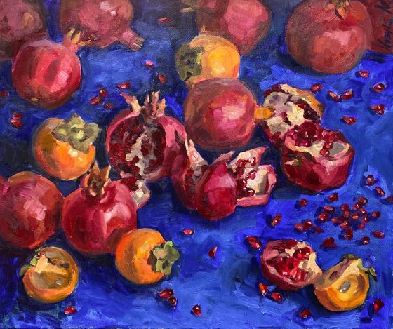 Pomegranates and persimmons on blue