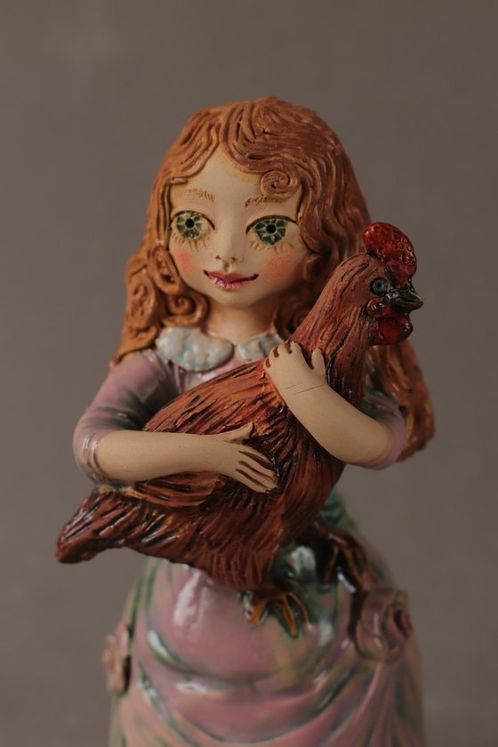 Vintage dressed girl holding a chicken.