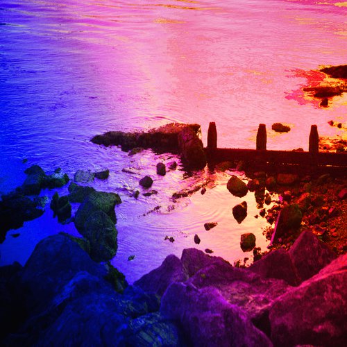 Purple Tide breaking on a Beach by Christopher West