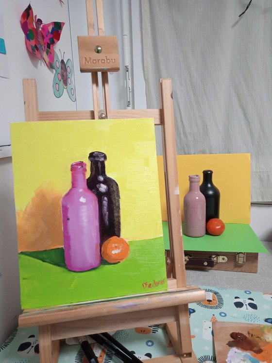 Colourful still life with two bottles and an orange tangerine