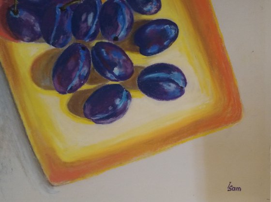 Blue plums on a yellow dish