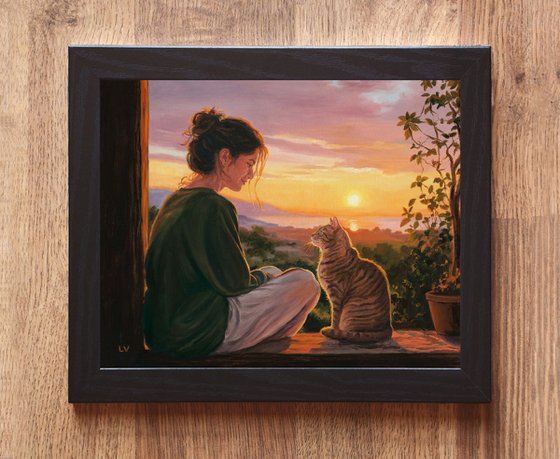 Girl watching the sunset with her tabby cat