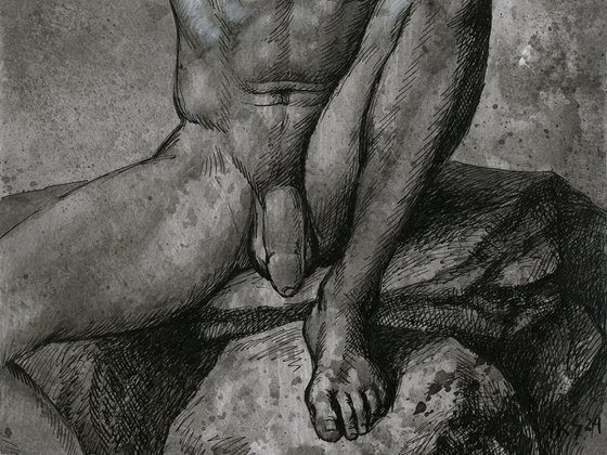 Nude young man sitting on rock