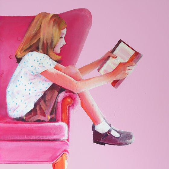 Girl in pink chair with book