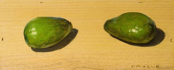 two green avocados on a wood board for food lovers