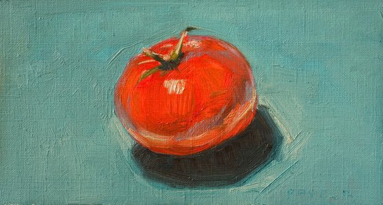 modern still life of very red tomato on a blue background