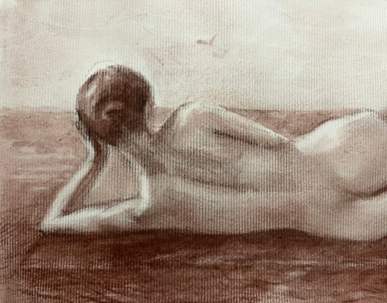 Nude woman from behind lying down on beach