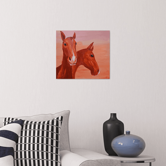 Chestnut horses at soft pink orange sunset