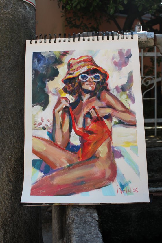 Girl in a red orange swimsuit and panama hat