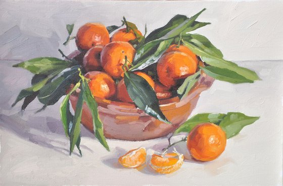 Clementines with leaves in an earthendish