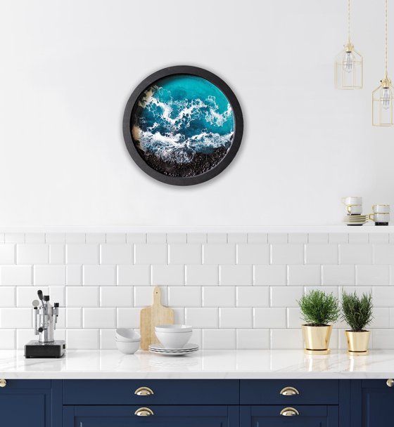 Round window overlooking the sea in a black frame