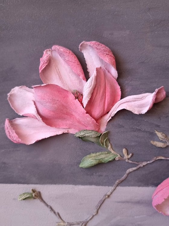 Pink Magnolia on a gray background. Relief still life with a branch of large flowers in a glass vase. Spring blooming