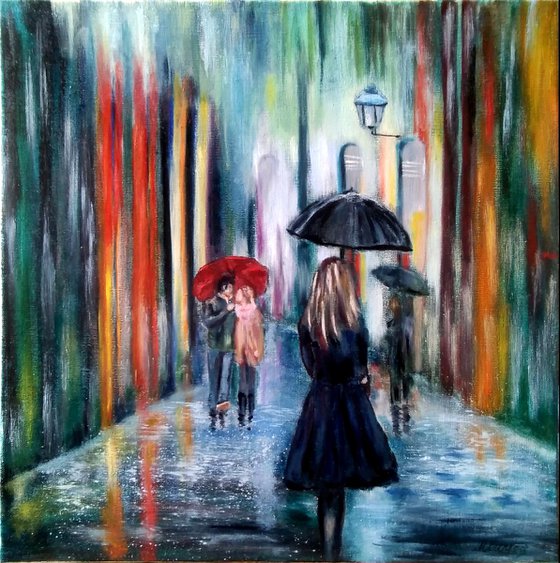 Rainy evening - Girl with an umbrella walks through the city