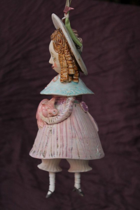 Vintage dressed girl holding a pig. Mini sculpture, unique ceramic bell doll.